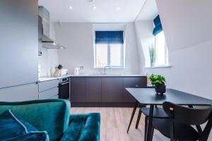 a kitchen with a table and a green couch at Southport Suites apartment 8 in Southport