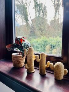 a window sill with two stuffed animals and a plant at Castle Gait Apartment in Paisley