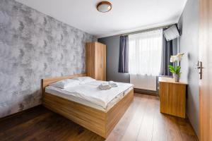 a bedroom with a wooden bed and a window at Sleep&Go in Lubliniec