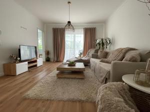 ein Wohnzimmer mit einem Sofa und einem TV in der Unterkunft PauliDrei in Leipzig