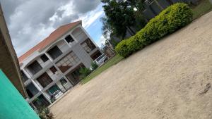 a building on the side of a dirt road at Jay Apartments in Mbarara