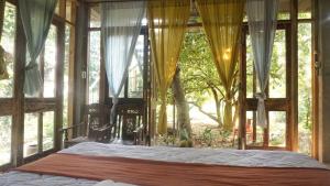 um quarto com uma cama e uma janela grande em Moon Garden Riverside em Thôn Kim Long (1)
