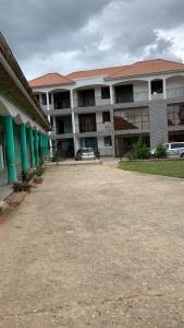 ein großes Gebäude mit einem Parkplatz davor in der Unterkunft Jay Apartments in Mbarara