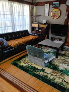 玉の浦sea في ناتشيكاتسورا: غرفة معيشة مع أريكة وطاولة