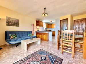 uma sala de estar com um sofá azul e uma cozinha em Casa Samsara 2 em Icod de los Vinos