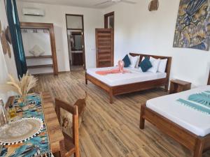 - un salon avec deux lits et une table dans l'établissement Haber Hotel & SPA, à Matemwe