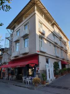 a building with tables and chairs in front of it at White Palace Büyükada in Adalar