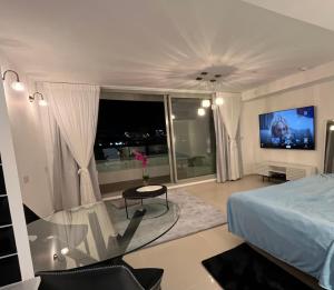 ein Schlafzimmer mit einem Bett und einem TV an der Wand in der Unterkunft סי סייד מפוארת באילת in Eilat