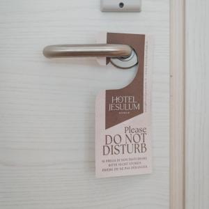 un cartello sulla porta con un cartello "Non disturbare" di Hotel Jesulum a Lido di Jesolo