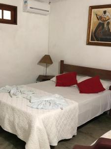 1 dormitorio con 2 camas y almohadas rojas en Pousada Estalagem Paraty, en Paraty