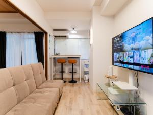 a living room with a couch and a flat screen tv at Shinjuku,Ushigome Yanagicho Sta 1min walk , Kabukicho3min in Tokyo