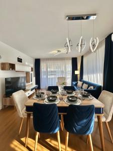 a dining room and living room with a table and chairs at Waves 605 River View in Sarajevo