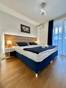 a bedroom with a large bed with a blue comforter at Waves 605 River View in Sarajevo
