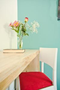un vaso di fiori seduto su un tavolo con una sedia di Residence Diamante a Villorba