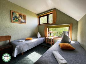 two beds in a small room with a window at Guest House Kalbakas in Smiltene