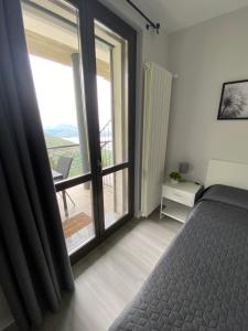 a bedroom with a bed and a view of a balcony at Dolcevista Apartment in Massino Visconti