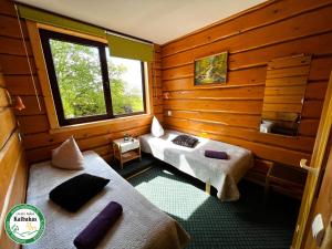 a room with two beds and a window at Guest House Kalbakas in Smiltene