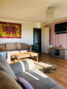 a living room with a couch and a table at ConnectU Apartment in Luton