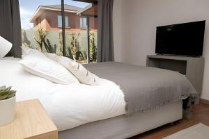 a bedroom with a bed and a flat screen tv at Cómoda y acogedora casa en Buin in Buin