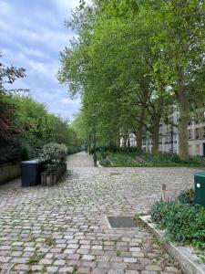 a cobblestone street in a park with trees and buildings at Beautiful and calm place in Saint-Maurice