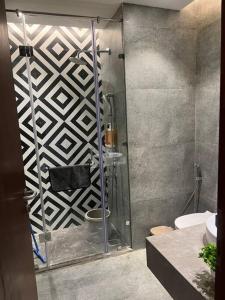 a bathroom with a glass shower with a toilet at The Silver Clouds 17th Floor Studio Apartment in Ghaziabad