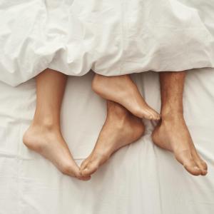 two people laying on a bed with their bare legs at PJs Hostel in Groningen