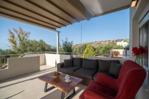 a living room with a couch and chairs on a balcony at Tranquil Retreat in Apokoronas - Chania in Kókkinon Khoríon