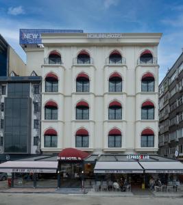 un gran edificio blanco con un restaurante frente a él en New Inn Hotel Old Town en Estambul