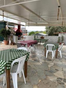 - un ensemble de tables et de chaises sur une terrasse dans l'établissement Village Holidays - Chelonaria, à Chrani