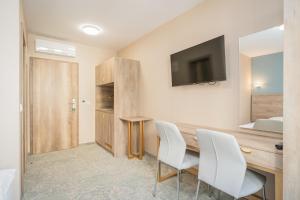 Zimmer mit einem Tisch, Stühlen und einem TV in der Unterkunft Rabie Aparthotel in Prag