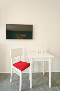 un tavolo bianco con una sedia rossa e un tavolo bianco di Residence Diamante a Villorba