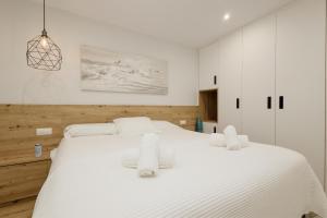 - une chambre blanche avec un grand lit blanc et 2 serviettes dans l'établissement Private infinity pool with sea views in La Mairena, Marbella, à Sitio de Calahonda