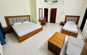 sypialnia z 2 łóżkami i kanapą w obiekcie Asroy Guest House w mieście Dhopāgul