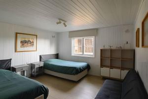 una camera con due letti e un divano in camera di Acogedora casa en la costa de Pelluhue a Chanco