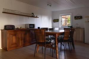 una cucina con tavolo e sedie in legno in una stanza di Acogedora casa en la costa de Pelluhue a Chanco
