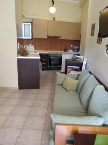 een woonkamer met een bank en een keuken bij N&M-Methana in Methana