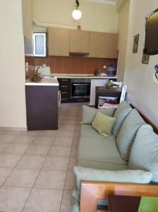 a living room with a couch and a kitchen at N&M-Methana in Methana