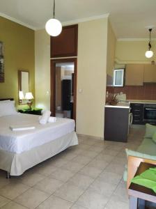 een slaapkamer met een groot bed en een keuken bij N&M-Methana in Methana