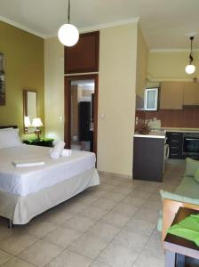 a bedroom with a large bed and a kitchen at N&M-Methana in Methana