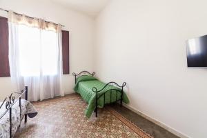 a bedroom with a bed with a green blanket on it at Fardella 250 in Trapani