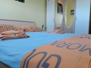 a bed with a blue comforter with the word buy on it at Rise and shine! in Pula