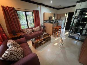 a living room with purple couches and a dog in it at Adayo Cove Resort in Siquijor