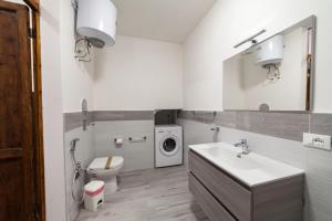 uma casa de banho com um lavatório, um WC e uma máquina de lavar roupa em Fardella 250 em Trapani