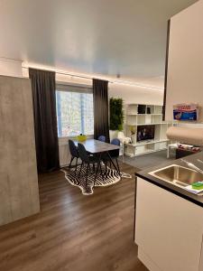 a kitchen with a table and chairs in a room at ChillOut Studio Apartment Lahti in Lahti