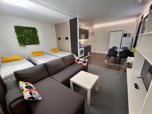 ein Wohnzimmer mit einem Sofa und einem Tisch in der Unterkunft ChillOut Studio Apartment Lahti in Lahti