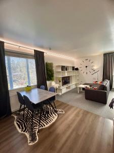 ein Wohnzimmer mit einem Tisch und einem Sofa in der Unterkunft ChillOut Studio Apartment Lahti in Lahti