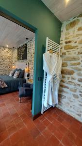 a living room with a bed and a stone wall at Les 3 Roses in Anjouin