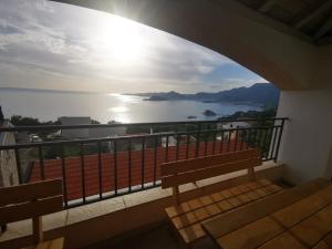 a balcony with a bench and a view of the water at Villa Anlave in Sveti Stefan