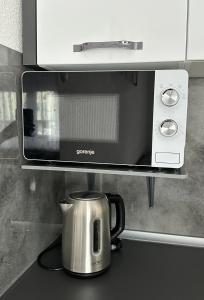 una macchinetta del caffè su un bancone sotto un forno a microonde di Apartman Lara Laktasi a Laktaši