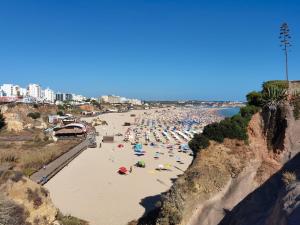a beach with a lot of people on it at Apartment Praia Rocha Tropical in Portimão